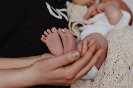 Mother and father holding baby feet in handsの写真素材