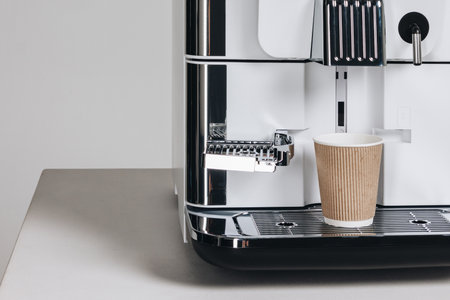 Fresh coffee from coffee machine brewing to paper cup
