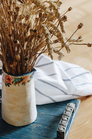 Ceramic vase with bouquet of dry wheat and poppyの写真素材