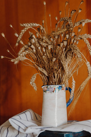 Ceramic vase with bouquet of dry wheat and poppyの写真素材