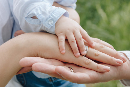 Hands of father, mother and infant kidの写真素材