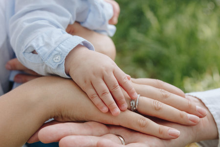 Hands of father, mother and infant kidの写真素材