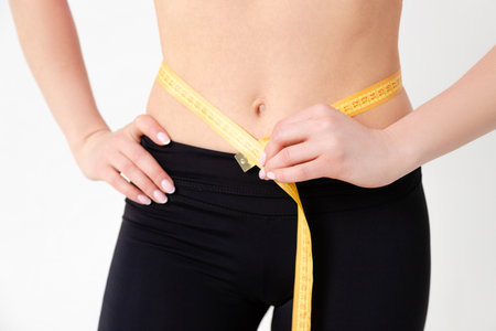 Fit woman measuring her waistの写真素材