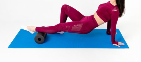 Unrecognizable caucasian woman doing exercises with roll on white backgroundの写真素材