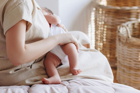 Young mother feeding breast her baby at homeの写真素材