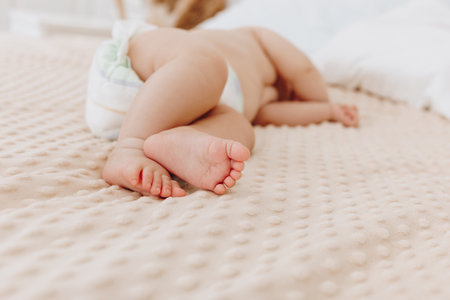Newborn baby in diaper sleeping on beige plaidの写真素材
