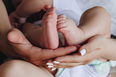 Mother and father holding baby feet in their handsの写真素材
