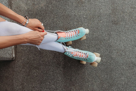 Close up photo of woman legs wearing cute green four wheeled roller bladesの写真素材