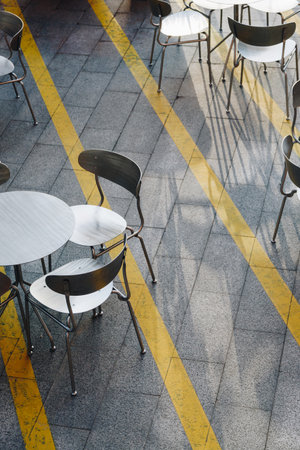 Street view of a cafe terrace with empty tables and chairsの写真素材