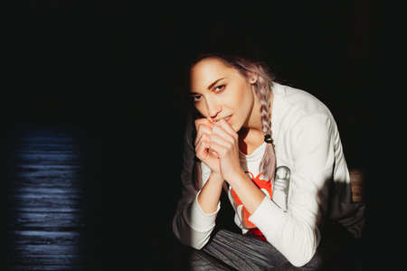 Beautiful young hipster woman with braids in mixed contrast lightの写真素材