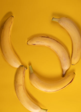 Ripe bananas on yellow backgroundの写真素材