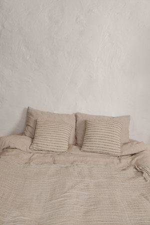 White simple wabi sabi bedroom design with comfortable bed with white sheets