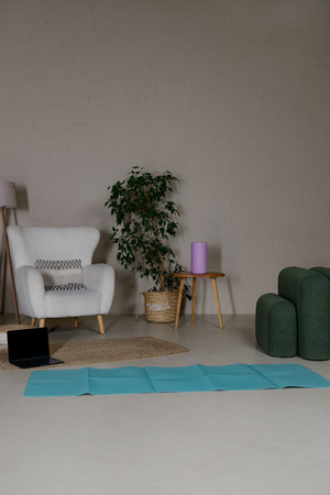 Stylish living room interior with boucle armchair, lamp and plant and blue matの写真素材