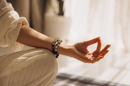 Closeup of woman hand in yoga symbolic gesture mudra wearing braceletsの写真素材