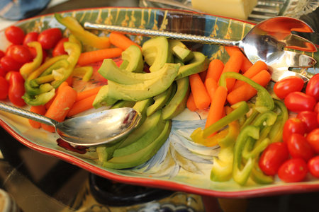 platter of vegetables with avocado,tomato,and carrotの写真素材