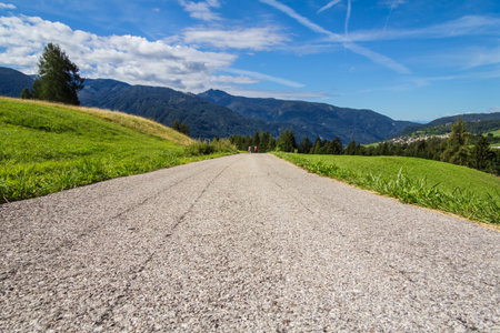 Walking on the mountain road in a sunny summer day.の写真素材