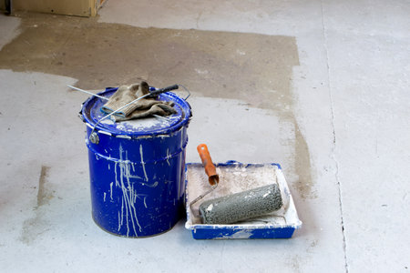Bucket with paint on the concrete floor. Roller for paint.の写真素材