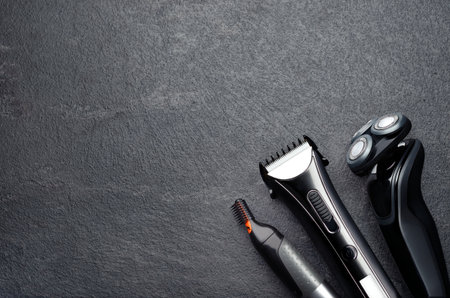 Electric shaver, trimmer, top view of arrangement of various barber tools on grey background. Studio photo.の写真素材