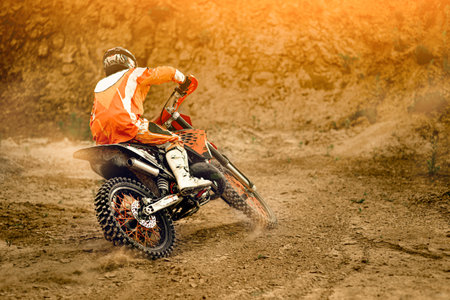 Side View of the Professional Motorcycle Rider Driving on the mountains and Further Down the...