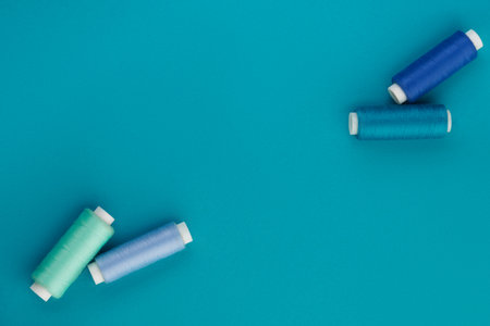 Blue thread. A set of spools of sewing thread. Several spools of thread in different shades of blue on a blue background. Top viewの写真素材