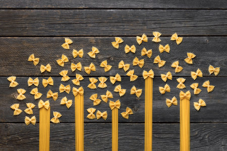 Italian food and cooking concept. Menu design. Various raw pasta on a gray wooden background. Pasta sketches. Italian Cuisine.の写真素材
