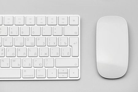 Keyboard and computer mouse close-up on a light gray background.