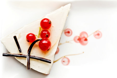 Cheesecake with red currant on white plate