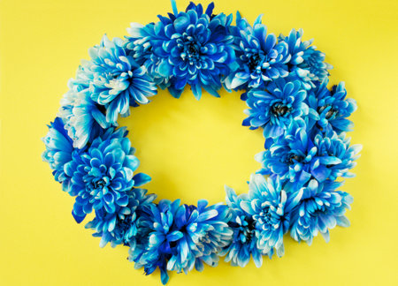 Pretty blue flower wreath on a yellow backgroundの写真素材