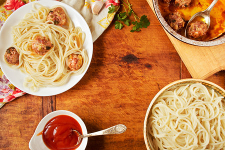 Spaghetti with meatballs in a plate on rustic wooden board with fresh parsley and ketchupの写真素材