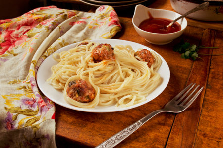 Pasta with meatballs and ketchup on wooden tableの写真素材