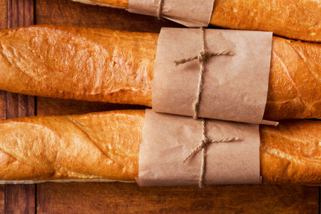 Freshly baked French baguettes on dark wooden table, close-upの写真素材