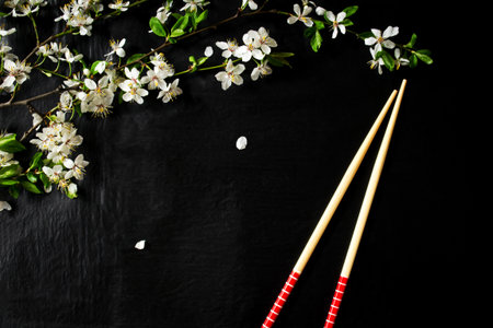 Composition with spring flowers and chopsticks on a black backgroundの写真素材