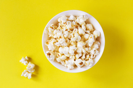 Popcorn in a bowl on a yellow backgroundの写真素材