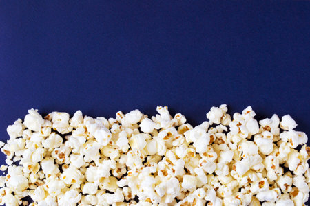 Salty popcorn on blue background, copy spaceの写真素材