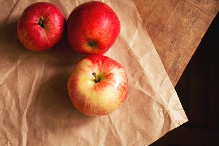 Three red apples on paper, top viewの写真素材