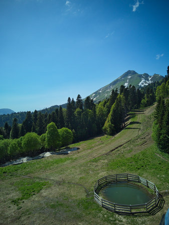 Mountain landscape with a lake and a fence in the foreground.の写真素材
