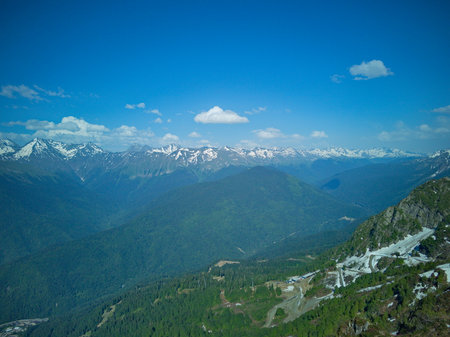 Mountain landscape with snow-capped peaks in the clouds.の写真素材