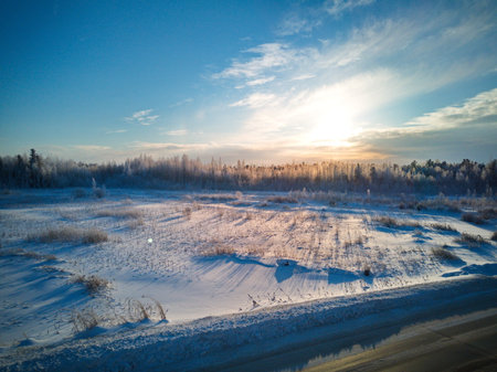 Winter sunset over the frozen river. Beautiful winter landscape with a frozen river.の写真素材