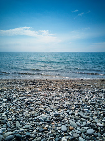 Beautiful seascape with pebble beach and blue skyの写真素材
