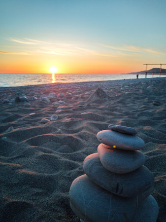 zen stones on the beach at sunrise, concept of harmony and balanceの写真素材