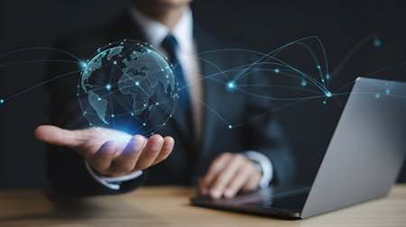 Businessman using laptop with digital globe hologram representing global network, technology innovation, and international business connection concept.の素材