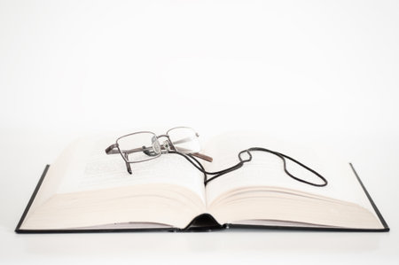 Open book with glasses on topの写真素材