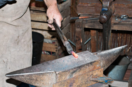 Artisan blacksmith working in his workshopの写真素材