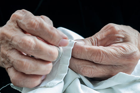 Detail of hands of elder sewing