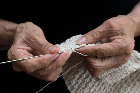 Detail of the hands of an elderly person crocheting