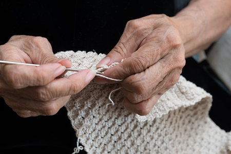 Detail of the hands of an elderly person crocheting