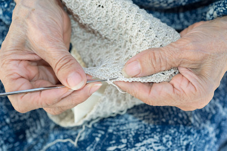 Detail of the hands of an elderly person crocheting