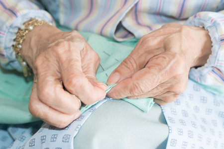 Detail of the hands of a senior person sewingの写真素材