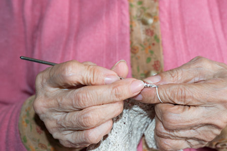 Detail of the hands of a senior person sewingの写真素材