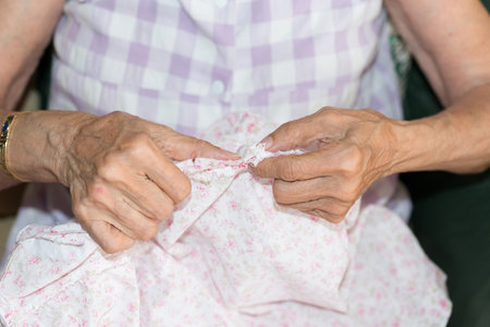 Detail of the hands of a woman sewing elderlyの写真素材